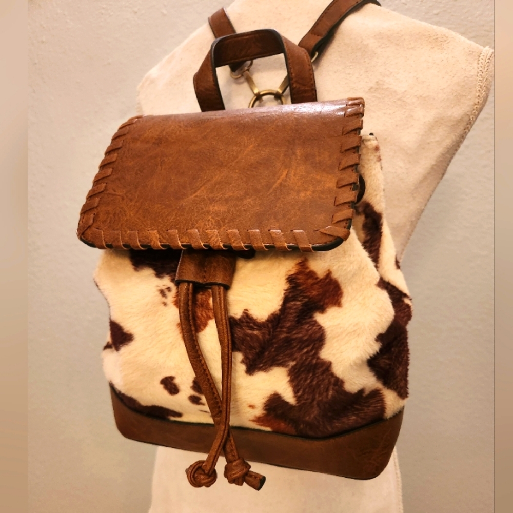 Jen & Co Kourtney Flap Over Drawstring Backpack In Cow Print